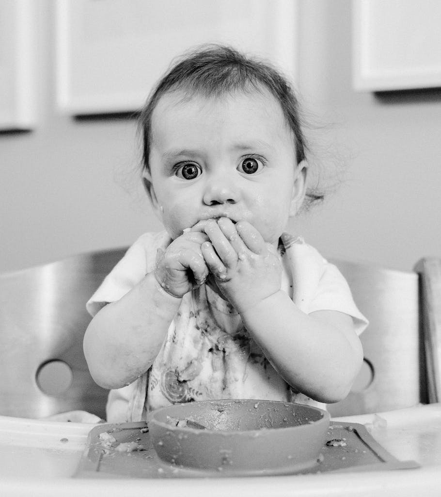 Black and White Portrait of Baby Making Mess while Eating